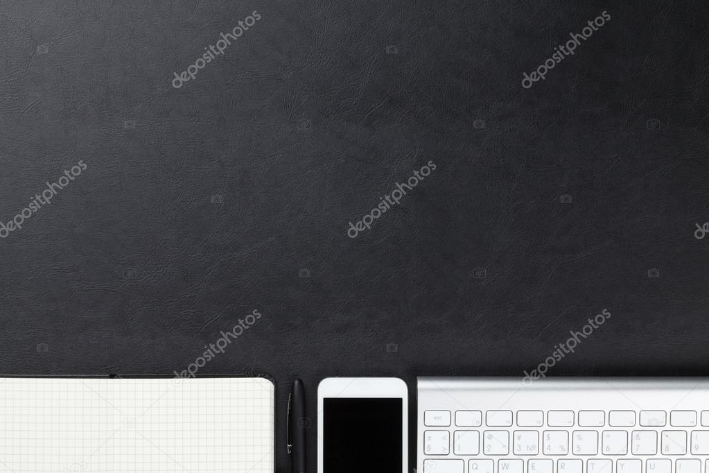 Desk with computer, supplies and smartphone