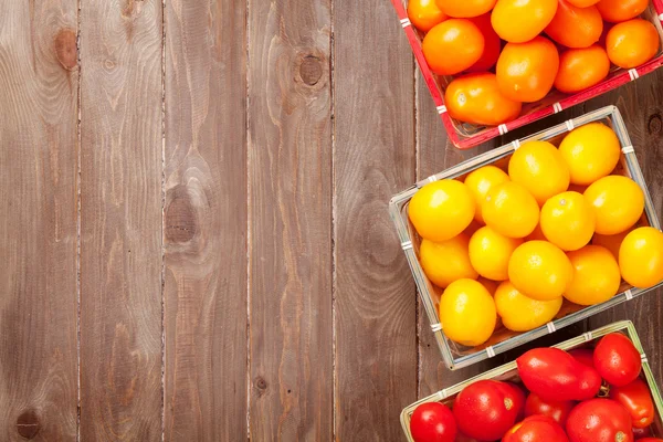 Colorful tomatoes on wooden table — Stock Photo, Image