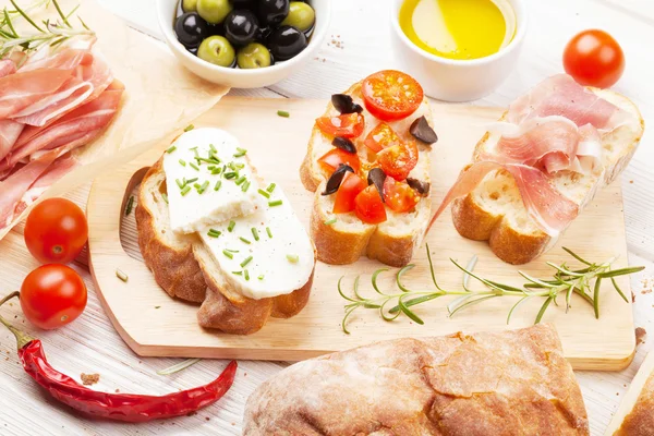 Bruschetta with cheese, tomatoes and prosciutto — Stock Photo, Image