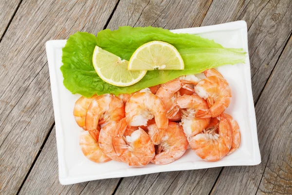 Cooked shrimps with lemon and salad leaves — Stock Photo, Image