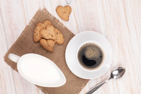 Coffee cup, heart shaped gingerbread cookies and milk pitcher — Stock Photo, Image