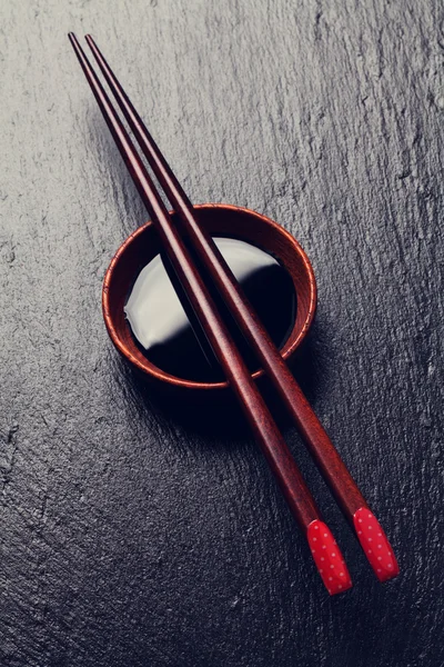 Sushi chopsticks sobre tigela de molho de soja — Fotografia de Stock