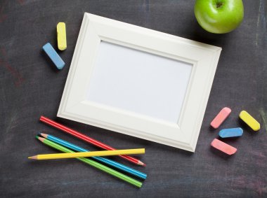 Blackboard arka plan üzerinde fotoğraf çerçevesi ve okul malzemeleri