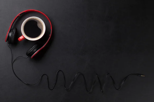 Auriculares y taza de café en el escritorio —  Fotos de Stock