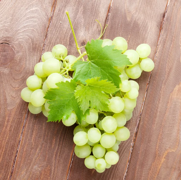 Ramo de uvas sobre mesa de madera —  Fotos de Stock