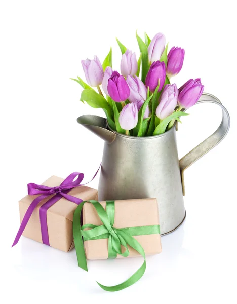 Buquê de tulipa roxa em regar lata e presentes — Fotografia de Stock