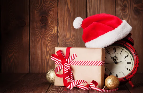 Christmas gift, clock and santa hat — Stock Photo, Image