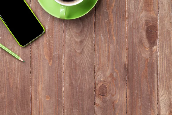 Fából készült íróasztal smartphone és kávé — Stock Fotó