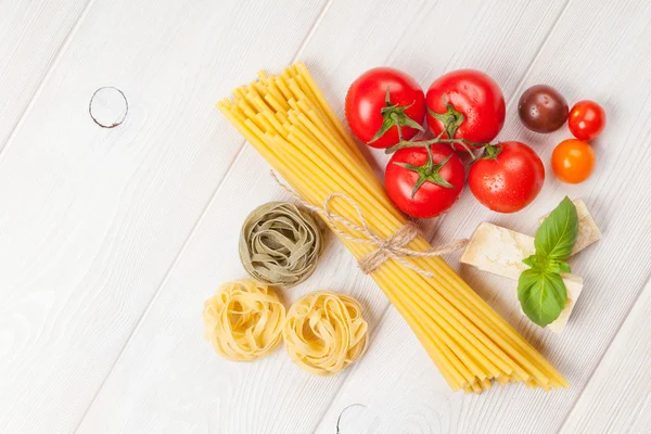 Pastas, tomates, albahaca sobre mesa de madera —  Fotos de Stock