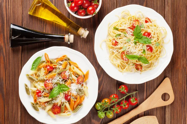 Spaghetti and penne pasta with tomatoes and basil — Stock Photo, Image