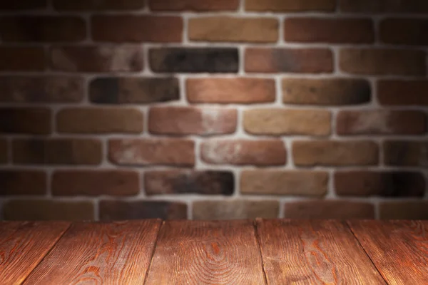 Houten tafel en bakstenen muur — Stockfoto