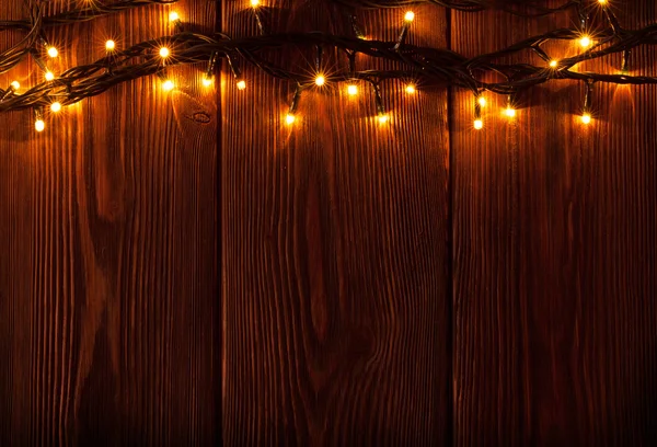 Światła świąteczne na drewnianym tle — Zdjęcie stockowe