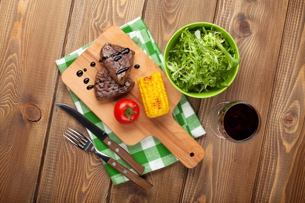 Bifes com milho grelhado, salada e vinho — Fotografia de Stock