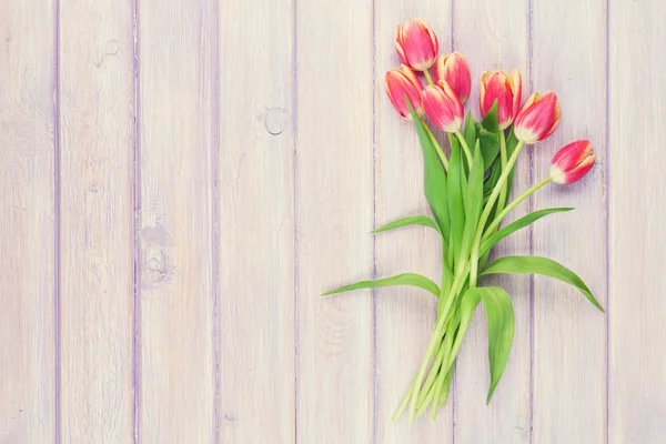 Rote Tulpen über violettem Holztisch — Stockfoto