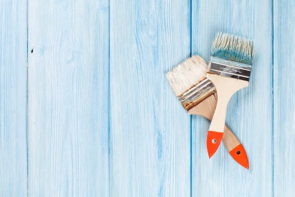 Paintbrushes over blue wood — Stock Photo, Image