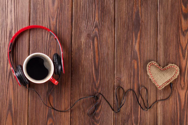 Juguete de corazón con auriculares y taza de café — Foto de Stock