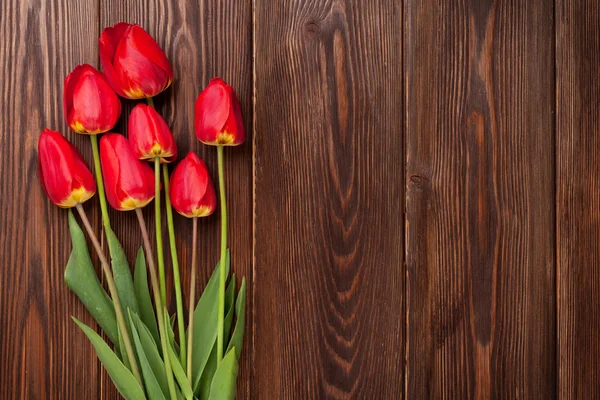 Red tulips bouquet over wood — Stock Photo, Image