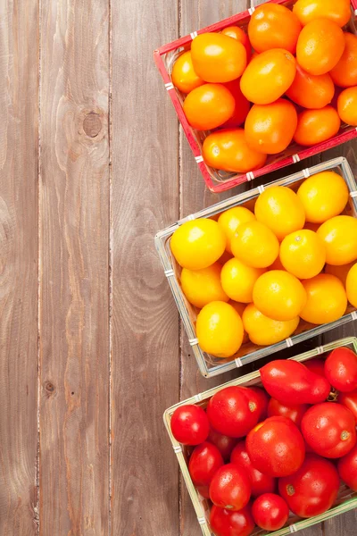 Colorful tomatoes on wooden table — Stock Photo, Image