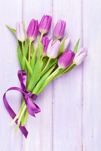 Purple tulips over wooden table — Stock Photo, Image