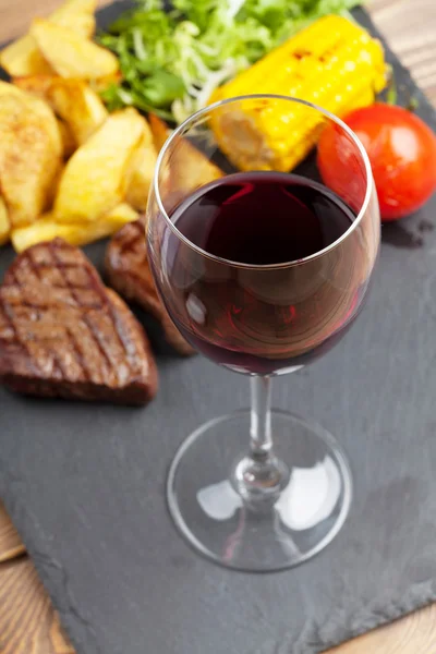 Copa de vino tinto y filete con patatas — Foto de Stock