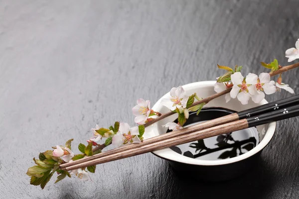 Suşi yemek çubukları, soya sosu ve sakura — Stok fotoğraf