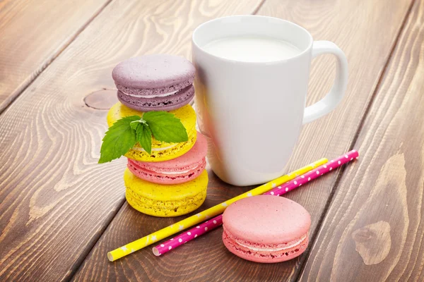 Colorful macaron cookies and cup of milk — Stock Photo, Image