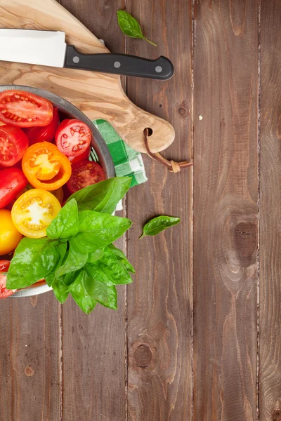 Fresh colorful tomatoes and basil in colander — Stock Photo, Image