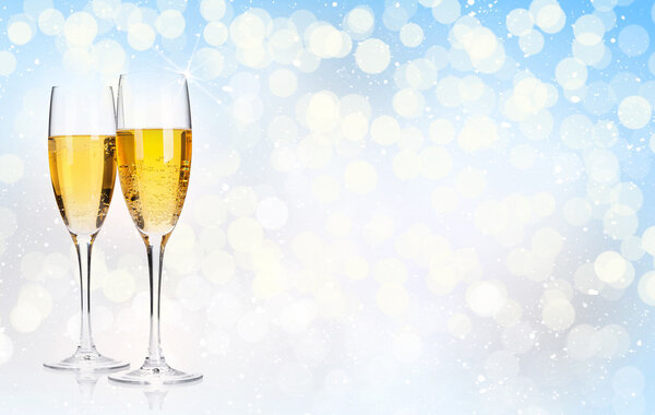 Two champagne glasses over christmas background