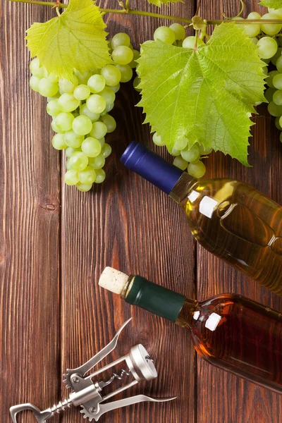 Hrozny, bílé láhve vína a vývrtka — Stock fotografie