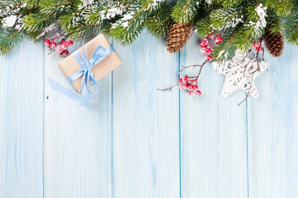 Kerstachtergrond met dennenboom en cadeau — Stockfoto