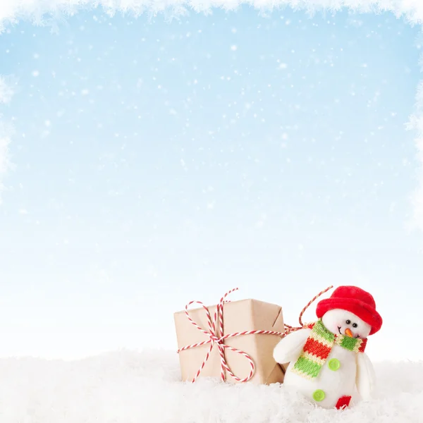 Caja de regalo de Navidad y muñeco de nieve en nieve —  Fotos de Stock