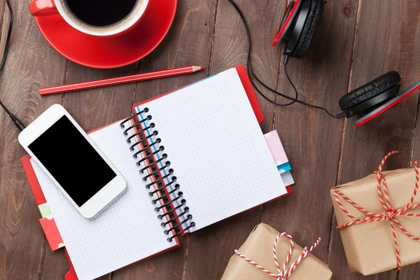 Desk with notepad and gift boxes — Stock Photo, Image