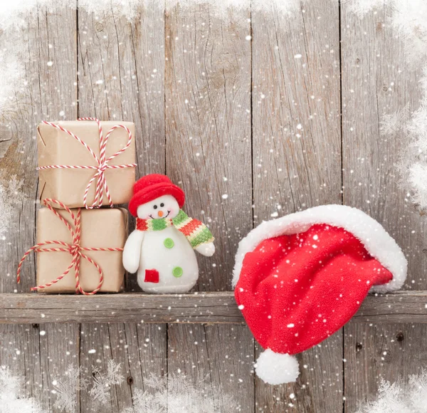 Vánoční dárkové krabičky, santa hat a sněhulák hračka — Stock fotografie