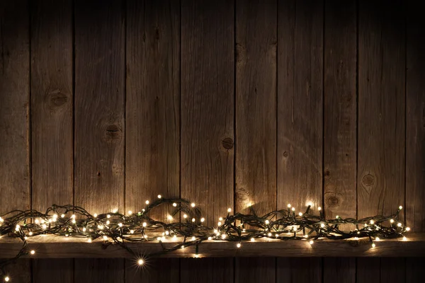 Luci di Natale davanti alla parete di legno — Foto Stock