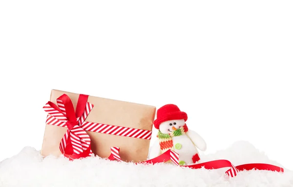 Christmas gift box and snowman in snow — Stock Photo, Image