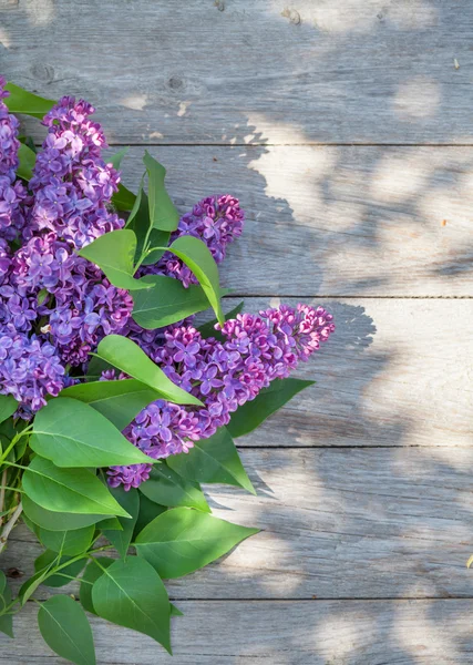 Фиолетовые сиреневые цветы на садовом столе — стоковое фото