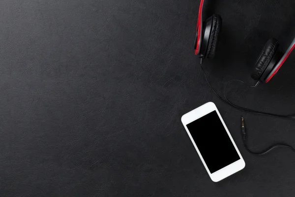 Ακουστικά και smartphone στο γραφείο τραπέζι — Φωτογραφία Αρχείου