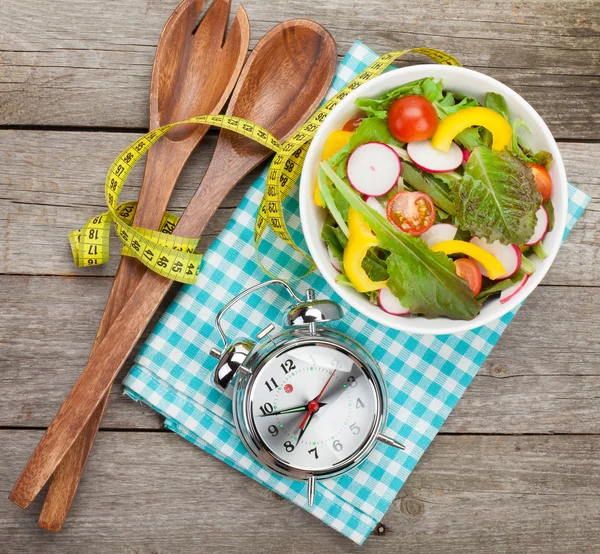Fresh healthy salad and measuring tape — Stock Photo, Image
