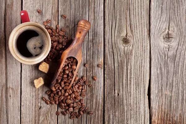 Šálek kávy a fazole na stole — Stock fotografie