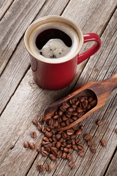 Kaffeetasse und Bohnen auf dem Tisch — Stockfoto