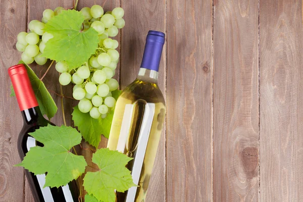 Bando de uvas e garrafas de vinho — Fotografia de Stock