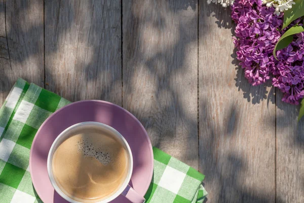 Coffee cup and colorful lilac flowers — Stock Photo, Image