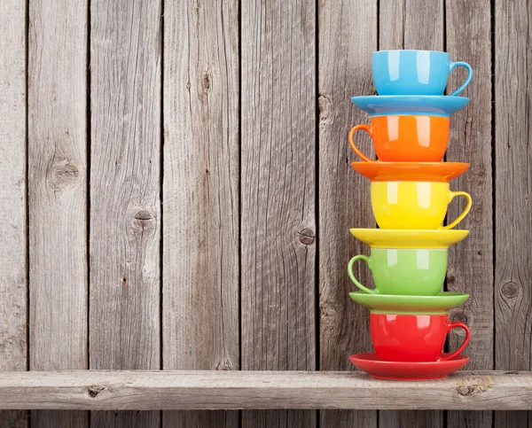 Colorful coffee cups on shelf — Stock Photo, Image