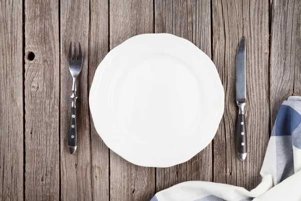 Empty plate and silverware on wooden table — Stock Photo, Image