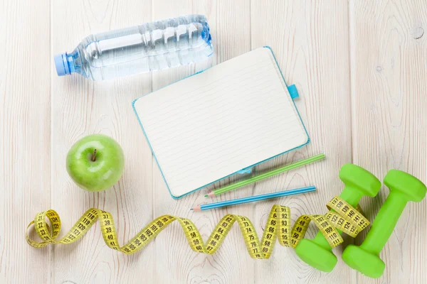 Dumbbells, water and notepad — Stock Photo, Image