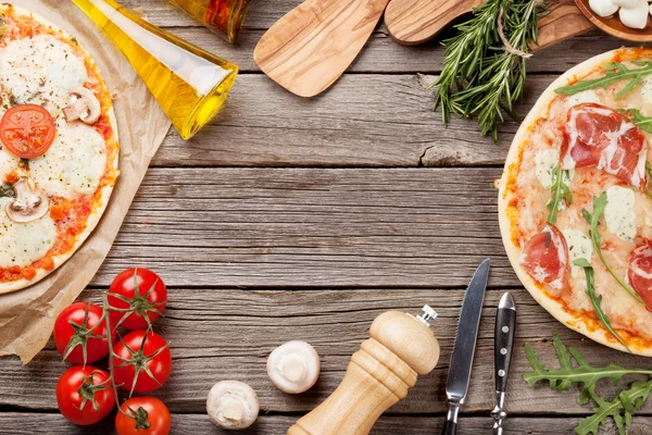 Pizza e ingredientes en mesa de madera — Foto de Stock