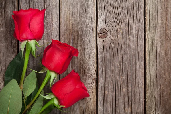 Κόκκινα τριαντάφυλλα πάνω από ξύλο — Φωτογραφία Αρχείου