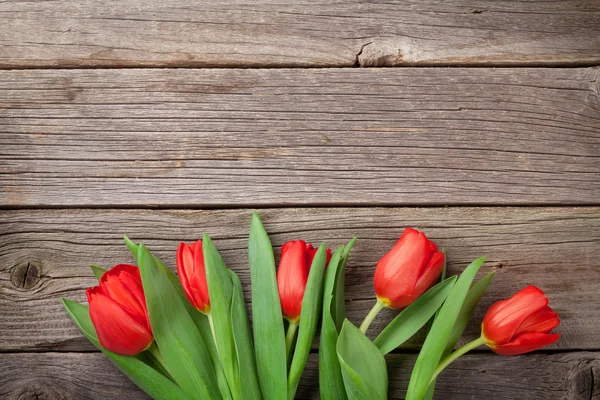 Red tulips over wood — Stock Photo, Image