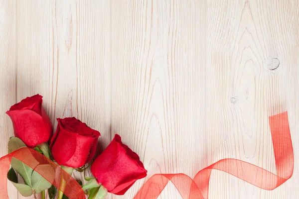 Red roses on wooden background