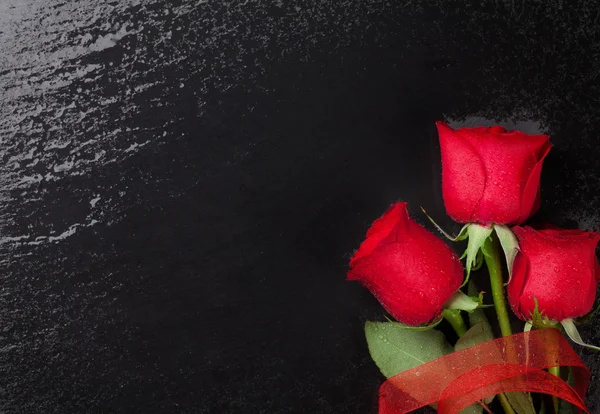 Rosas vermelhas sobre fundo de pedra preta — Fotografia de Stock